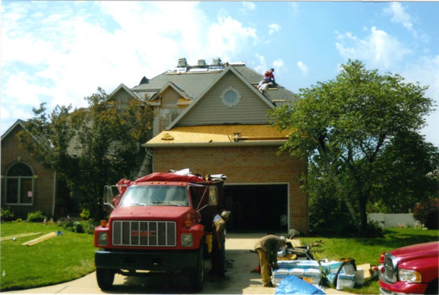 Gottschalk Brothers crew tearing off and replacing a two-story roof, company GMC truck in the driveway